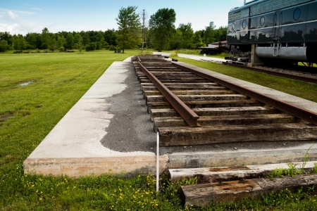Train tracks alongside a locomotive rest on a concrete pad in the country near Albany, NY の写真素材