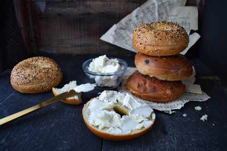 Assorted Bagels with cream cheese on rustic table with music sheetsの写真素材