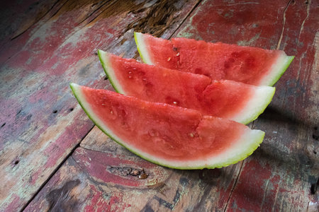 watermelon slices on wooden table in rustic settingの写真素材