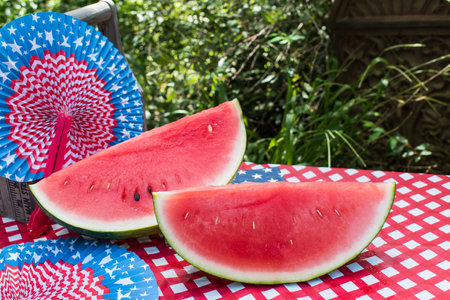 Sunny Fourth of July table with watermelon and red white and blue fansの写真素材