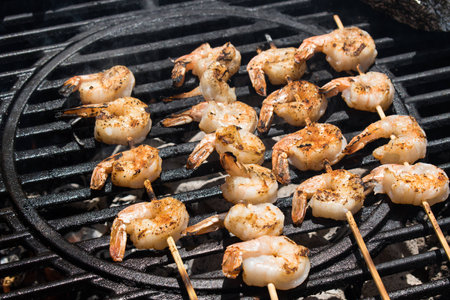 Shrimp kabobs on round grill over hot coalsの写真素材