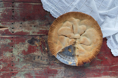handmade apple pie on rustic table with white linenの写真素材