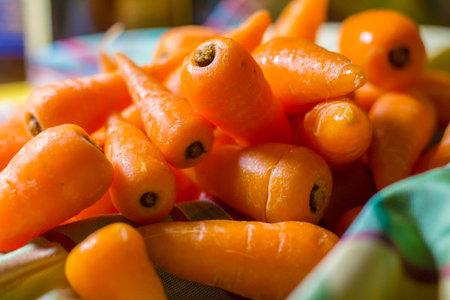 Raw chantenay carrots in a pile on a table cloth