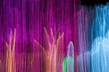 Wavy multicolored glowing lines against a dark background long exposure shotの写真素材