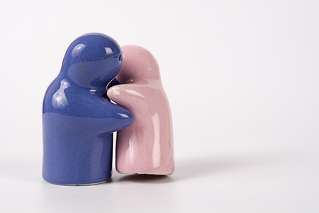 Ceramic toys is hugging his couple for their love on white backgroundの写真素材