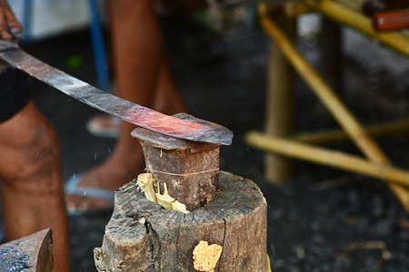 Blacksmith working on metal on anvil at forge detail shotの写真素材