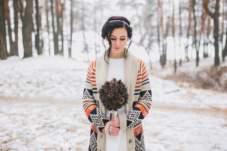 Bride holding wedding bouquet made of pine conesの写真素材