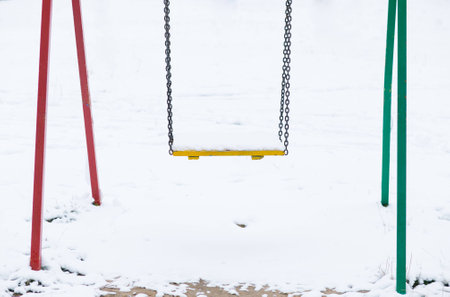 Swing in snow on the playgroundの写真素材