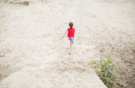 Boy running barefoot at the beach. の写真素材