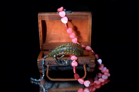 Opened coffer and necklaces isolated on a black.の写真素材