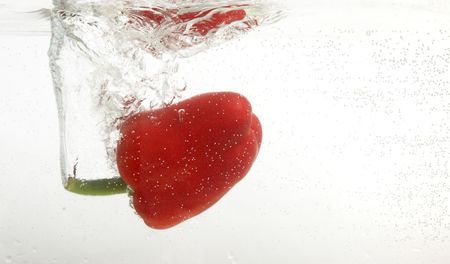 Pepper is dropped into clean water.の写真素材