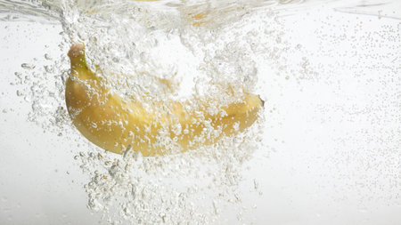 Fresh banana is falling into clean water.の写真素材