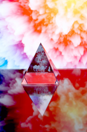 Transparent pyramid with bedouin situated opposite abstractions background.の写真素材