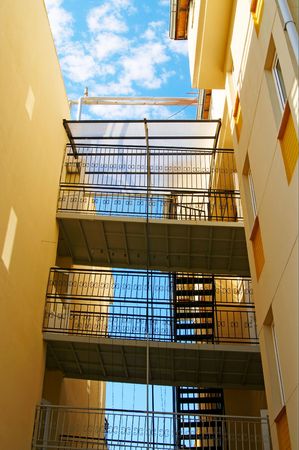 Fire escape  against blue cloudy sky.の写真素材