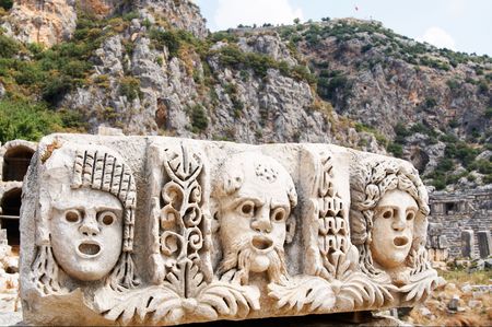 Masks and rock tombs in Myra, Turkey.の写真素材