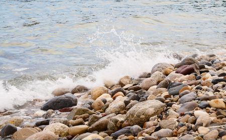 Sea foam and pebble in the water.の写真素材