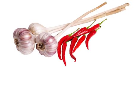 Ripe garlics and red peppers isolated on a white background.の写真素材