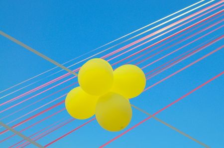 Flying  splendid yellow balloons under a blue sky with clouds. の写真素材