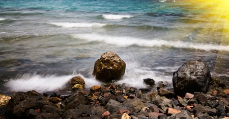 Anxious sea-wave and stones at the coastline.の写真素材