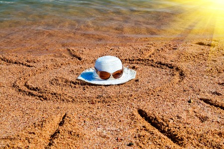 Eyewear,hat and sun drew on the sandy beach.の写真素材