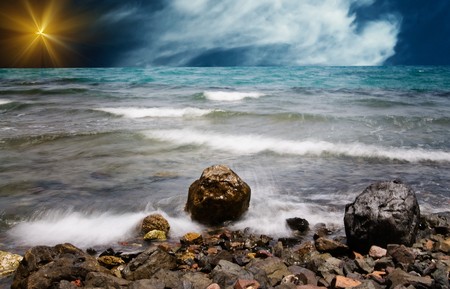 Anxious sea-wave and stones at the coastline.の写真素材