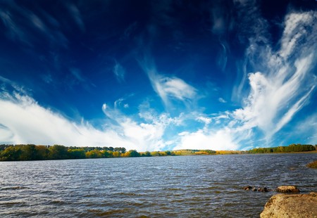 Wonderful autumn lake and blue sky with white clouds.   の写真素材