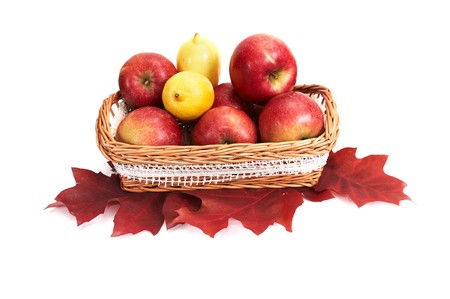 Wooden  basket full of autumn apples and lemons isolated on a white background.の写真素材