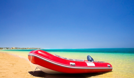 Single red inflatable lifeboat on the beach  の写真素材