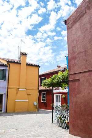 Colorful buildings an a leaning tower of an old church on Burano island, Venice, Italy.の写真素材