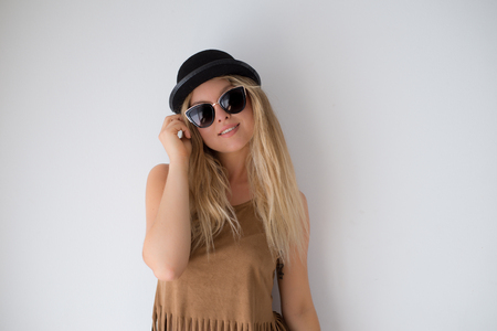 Young blonde hipster woman, , funny face, posing at home at sunny day, stylish hat and clear sunglasses.の写真素材