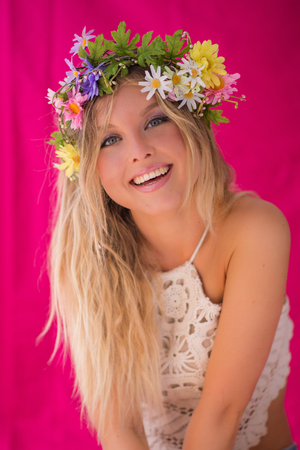 Beautiful blonde woman with flower wreath on her head. Beauty girl with flowers hairstyle. Perfect makeup. Beauty fashion. Spring womanの写真素材