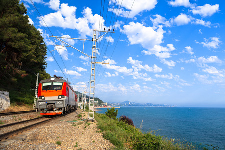 A  red train goes along the shore, Black sea, Russiaのeditorial素材