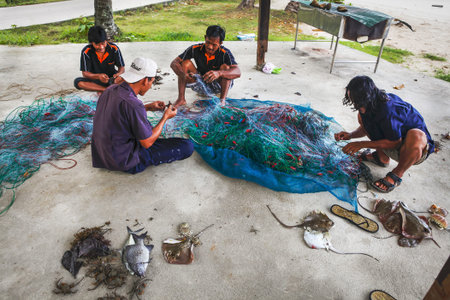 Ko Chang Island, Thailand - April 09, 2011: - thai fishermen sorting their catch on the shoreのeditorial素材