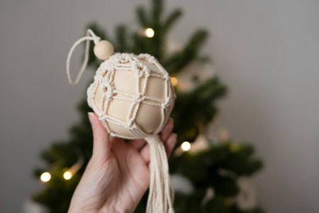 A woman's hand holds a handmade toy for the Christmas treeの写真素材