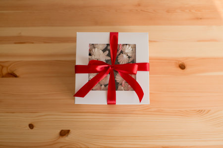 Baked goods in a white box with a red satin ribbonの写真素材