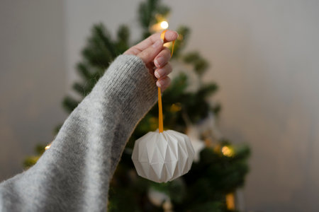 A woman's hand holds a handmade toy for the Christmas treeの写真素材