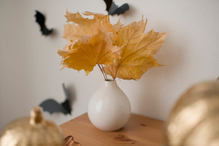 Autumn yellow leaves in a white ceramic vaseの写真素材