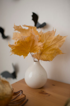 Autumn yellow leaves in a white ceramic vaseの写真素材