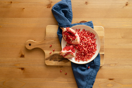 Pomegranate fruit lies on a plate on the table, top view.の写真素材