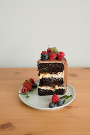 A piece of cake decorated with berries on a plateの写真素材