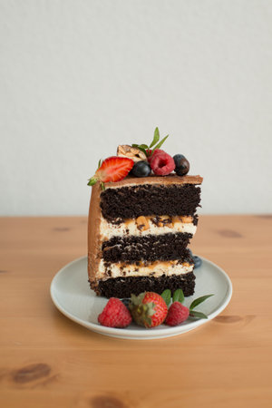 A piece of cake decorated with berries on a plateの写真素材