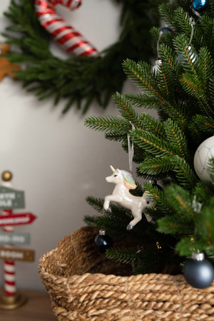 A toy for a Christmas tree hanging on a branch, a unicorn made of ceramicsの写真素材