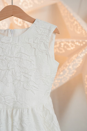 White festive dress hanging on a wooden hangerの写真素材
