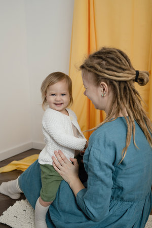 Mother and daughter playing together at home. Concept of friendly family.の写真素材
