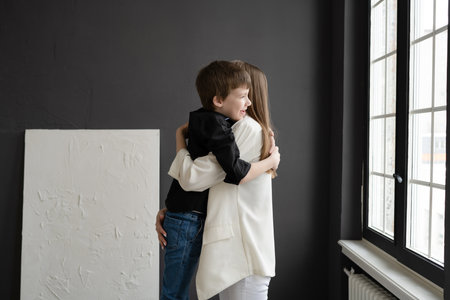 Portrait of a little boy hugging her mother in the room.の写真素材