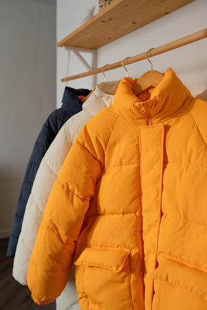 Yellow winter jacket on hanger in wardrobe, closeup. winter clothesの写真素材