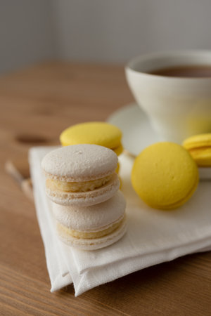 Macaroon and cup of tea on a wooden table, close upの写真素材