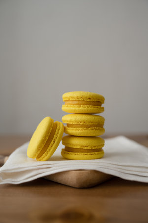Yellow macaroon on a white napkin on a wooden tableの写真素材