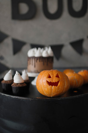 Halloween cake with pumpkin and cupcakes on dark background, selective focusの写真素材