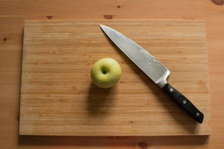 Knife and apple on a cutting board.の写真素材